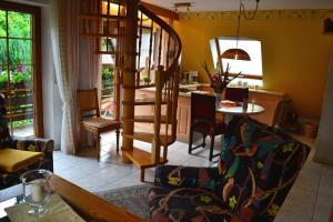 a living room with a spiral staircase leading to a kitchen at Haus Bachschwalbe in Sasbachwalden