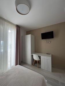 a bedroom with a bed and a desk with a television at Tenuta il Bandito in Montesano Scalo