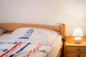 a bedroom with a bed with a lighthouse pillow on it at Bungalow Seeschwalbe, Nr 7 in Dranske