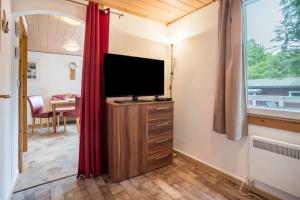 a living room with a television and a window at Bungalow Seeschwalbe, Nr 7 in Dranske