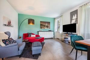 a living room with a red couch and a flat screen tv at Ferienwohnung Kronsberg mit Sauna in Bösel