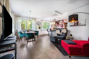 a living room with a red couch and a table at Ferienwohnung Kronsberg mit Sauna in Bösel