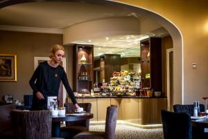 a woman standing at a table in a restaurant at York House Hotel in Whitley Bay