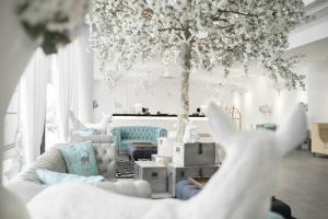 a living room with a couch and a tree at Creator Hotel in Kulai
