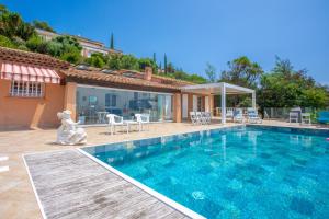 a house with a swimming pool and a patio at Studio Palmeraie in Saint-Raphaël