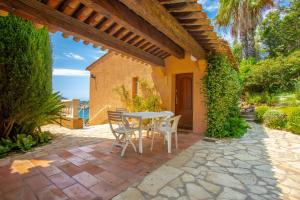 a patio with a table and chairs on a brick patio at Studio Palmeraie in Saint-Raphaël