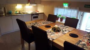 a kitchen with a wooden table with chairs and a dining room at Granbergs Gästhem in Eckerö +6 photos