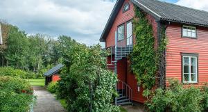 a red house with ivy growing on the side of it at Granbergs Gästhem in Eckerö