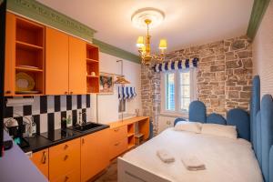 a kitchen with orange cabinets and a table in a room at Casa Libertà Suites & Studios Piran in Piran