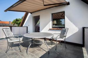 a patio with a table and chairs on a balcony at Ferienwohnung Spallholtz in Stralsund