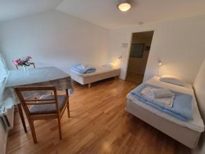 a small room with two beds and a table at Granbergs Gästhem in Eckerö