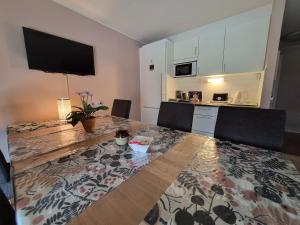 a living room with a table and a kitchen at Granbergs Gästhem in Eckerö