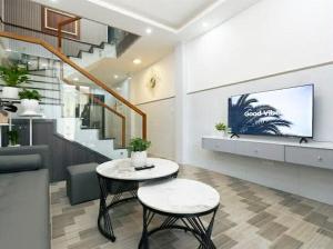 a living room with a table and a tv at Sky Home in Da Lat