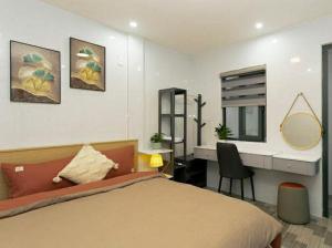 a bedroom with a bed and a desk with a mirror at Sky Home in Da Lat