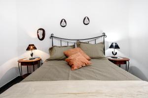 a bedroom with a bed with two end tables at Casa das Hortênsias in Raminho