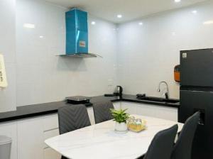 a kitchen with a table with chairs and a refrigerator at Sky Home in Da Lat