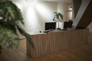 an office with two computers on a wooden reception desk at Creator Hotel in Kulai