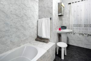 a bathroom with a tub and a toilet and a sink at Casa das Hortênsias in Raminho +25 photos