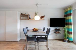 a dining room with a table with chairs and a tv at Ferienappartement Magjar in Küssaberg