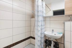 a bathroom with a sink and a shower curtain at Ferienappartement Magjar in Küssaberg +12 photos