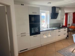 a kitchen with white cabinets and a stove top oven at Sonnenhang in Sigmarszell