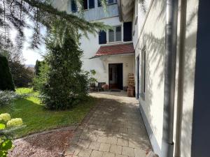 a white house with a pathway leading to a door at Sonnenhang in Sigmarszell +2 photos