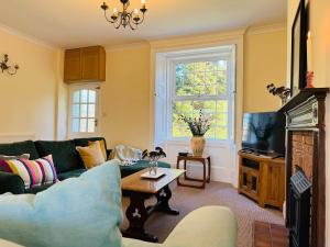 a living room with a couch and a tv at Meadow Cottage in King's Lynn