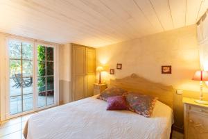 a bedroom with a large bed and a window at Le Patio in Velleron +20 photos