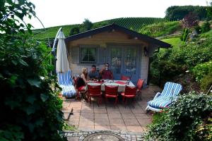 a group of people sitting at a table with an umbrella at Haus Bachschwalbe in Sasbachwalden