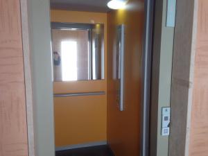 オリスターノにあるCasa Fenughedduの窓付きのオレンジ色のドアがある廊下
