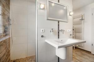 a white bathroom with a sink and a shower at Reethaus Meerferien in Poseritz +35 photos