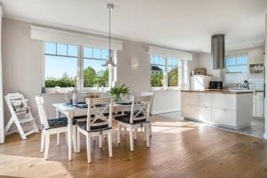 a kitchen and dining room with a table and chairs at Reethaus Meerferien in Poseritz