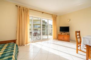 a living room with a bed and a television at Villa Marachique 205 in Alvor