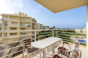 a balcony with a table and chairs and a building at Villa Marachique 205 in Alvor