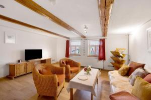 a living room with a couch and chairs and a tv at Ferienwohnung Gartenfreude in Veckenstedt