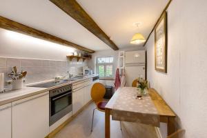 a small kitchen with a table and a sink at Ferienwohnung Gartenfreude in Veckenstedt
