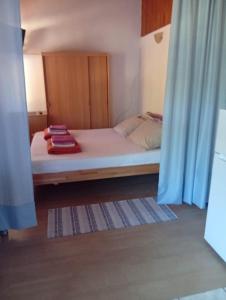 a bedroom with a bed with towels on it at Apartman Mira in Karlobag
