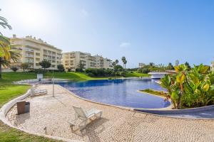 a swimming pool in a resort with chairs and condos at Villa Marachique 205 in Alvor