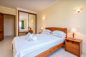 a bedroom with a large bed with towels on it at Villa Marachique 205 in Alvor +17 photos