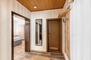 a hallway with a wooden door and a mirror at Fewo45 in Homberg