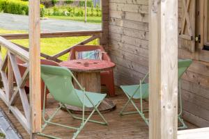 a patio with chairs and a table on a porch at Chalet 5 personnes, proche canal in Landeleau