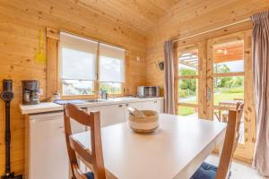 a kitchen with a table and a sink and a window at Chalet 5 personnes, proche canal in Landeleau