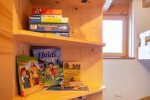 a book shelf with books on it at Kreuzplonhof Apt Karspitz in Luson