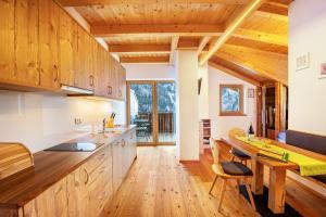 a kitchen with wooden cabinets and a wooden table at Kreuzplonhof Apt Karspitz in Luson