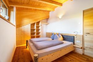 a bed in a room with a wooden ceiling at Kreuzplonhof Apt Karspitz in Luson