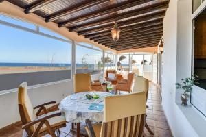 a dining room with a table and chairs on a balcony at Villa Rústica con piscina privada in Tías