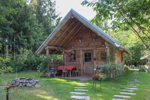 a small wooden cabin with a table in the yard at Ferienwohnung Haus am Wald in Judenbach