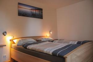 a bedroom with two beds with lights on the wall at Ferienwohnung Haus am Wald in Judenbach