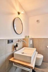 a bathroom with a white sink and a mirror at Alte Seifensiederei - Jane in Bad Tölz
