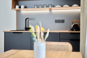 a kitchen with a table and a counter with a tea kettle at Alte Seifensiederei - Jane in Bad Tölz +11 photos